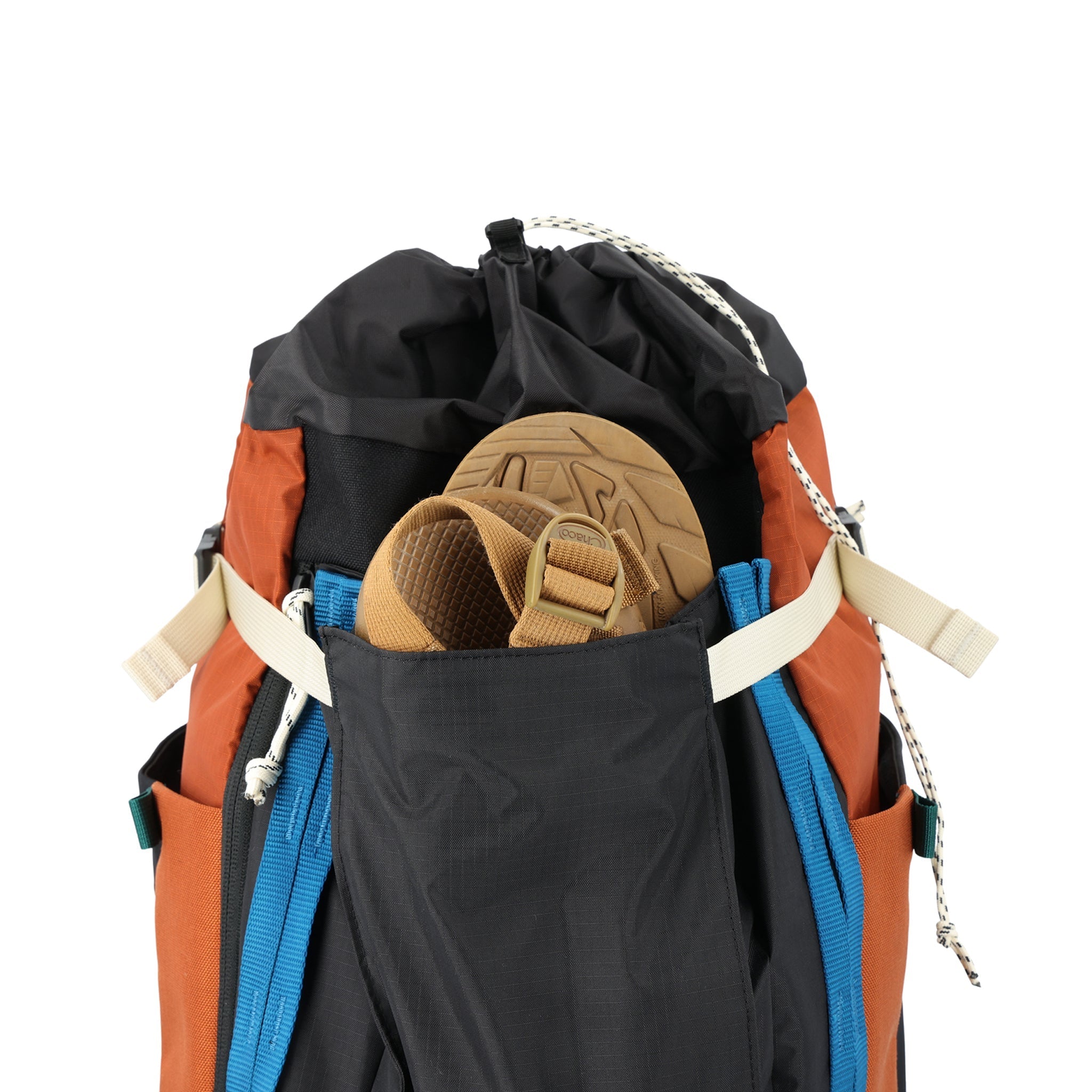 General shot of sandals inside front stash pocket of Topo Designs Mountain Pack 28L hiking backpack with external laptop sleeve access in lightweight recycled clay orange black nylon.