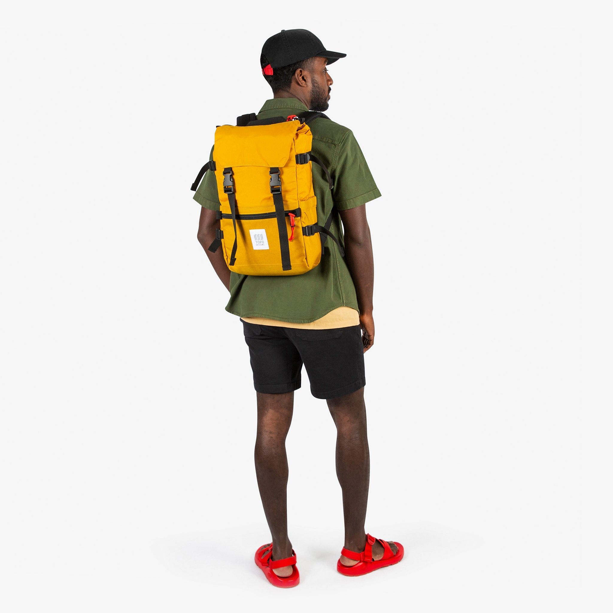 Topo Designs Rover Pack Classic in "Mustard" yellow carried by model with backpack straps.