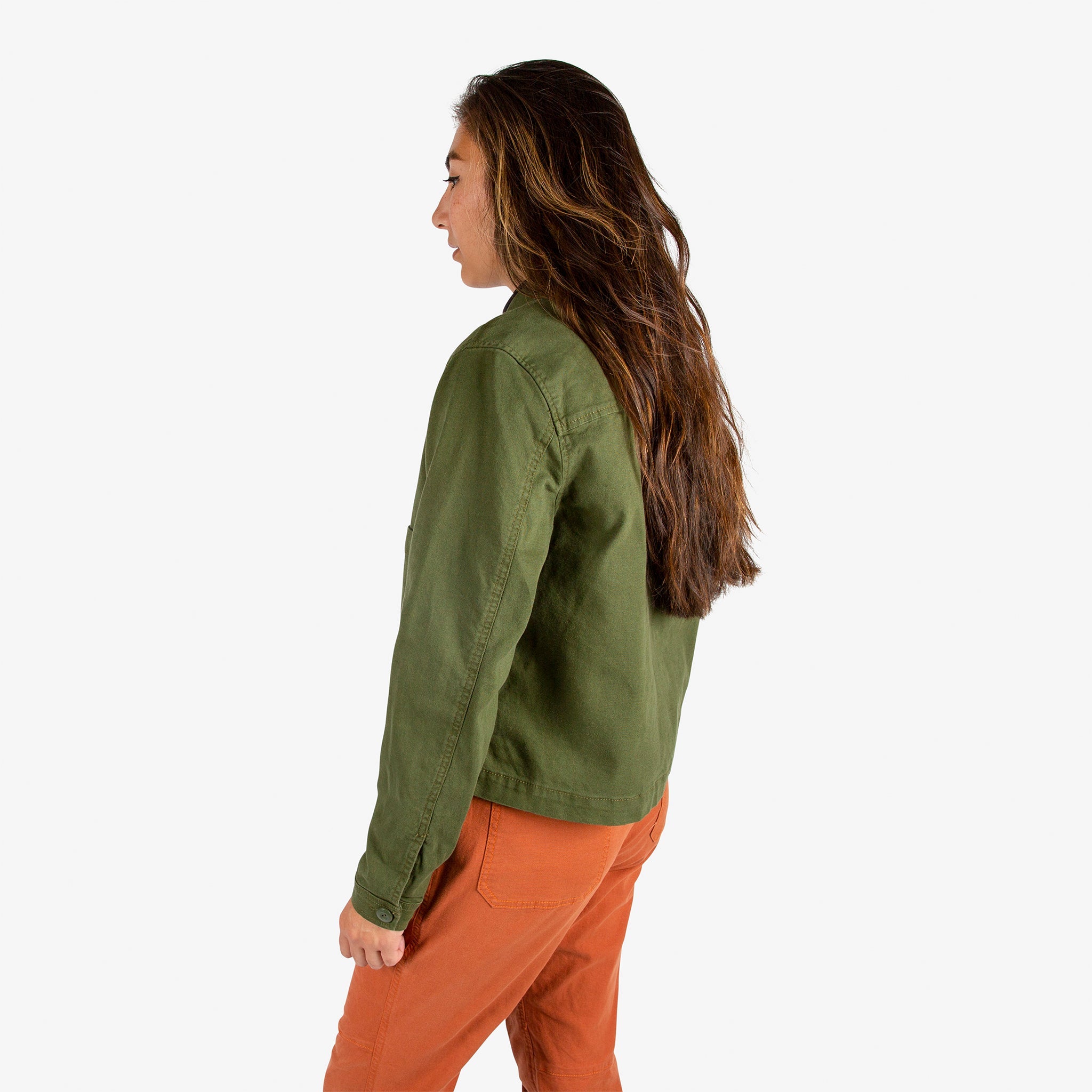 Side model shot of Topo Designs Women's Dirt Jacket in "Olive" green & Dirt Pants in Brick orange.