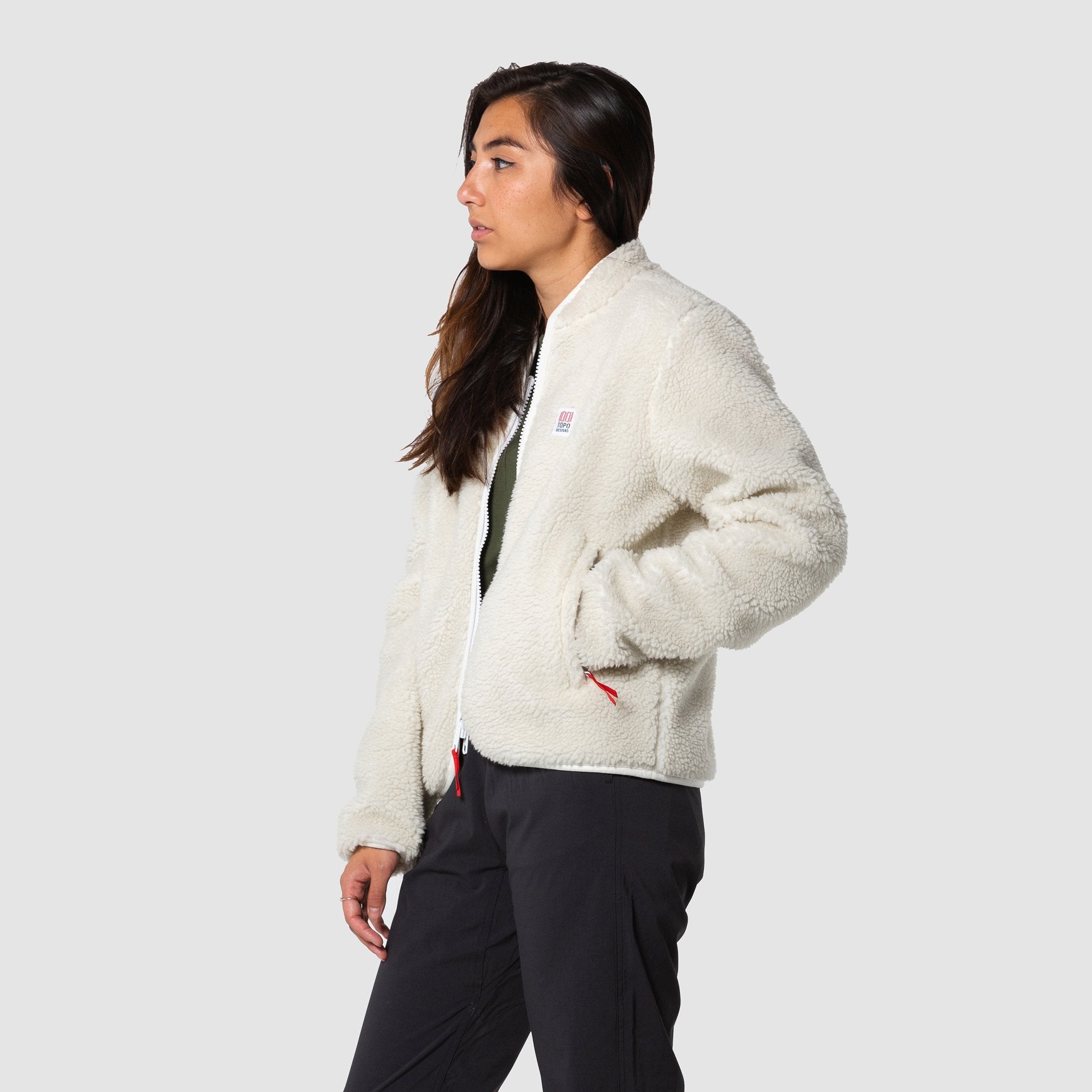 Side model shot of the sherpa jacket in "natural / khaki" showing the sherpa fleece unzipped