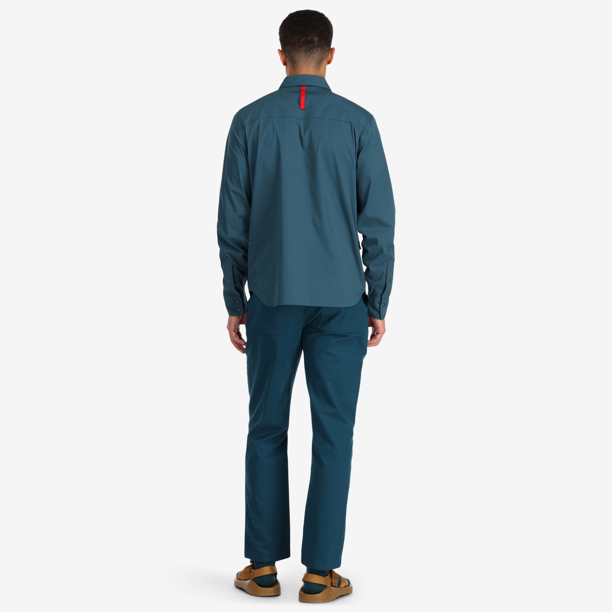 Back model shot of Topo Designs Men's Global Shirt long sleeve lightweight travel snap shirt in "Pond Blue". 