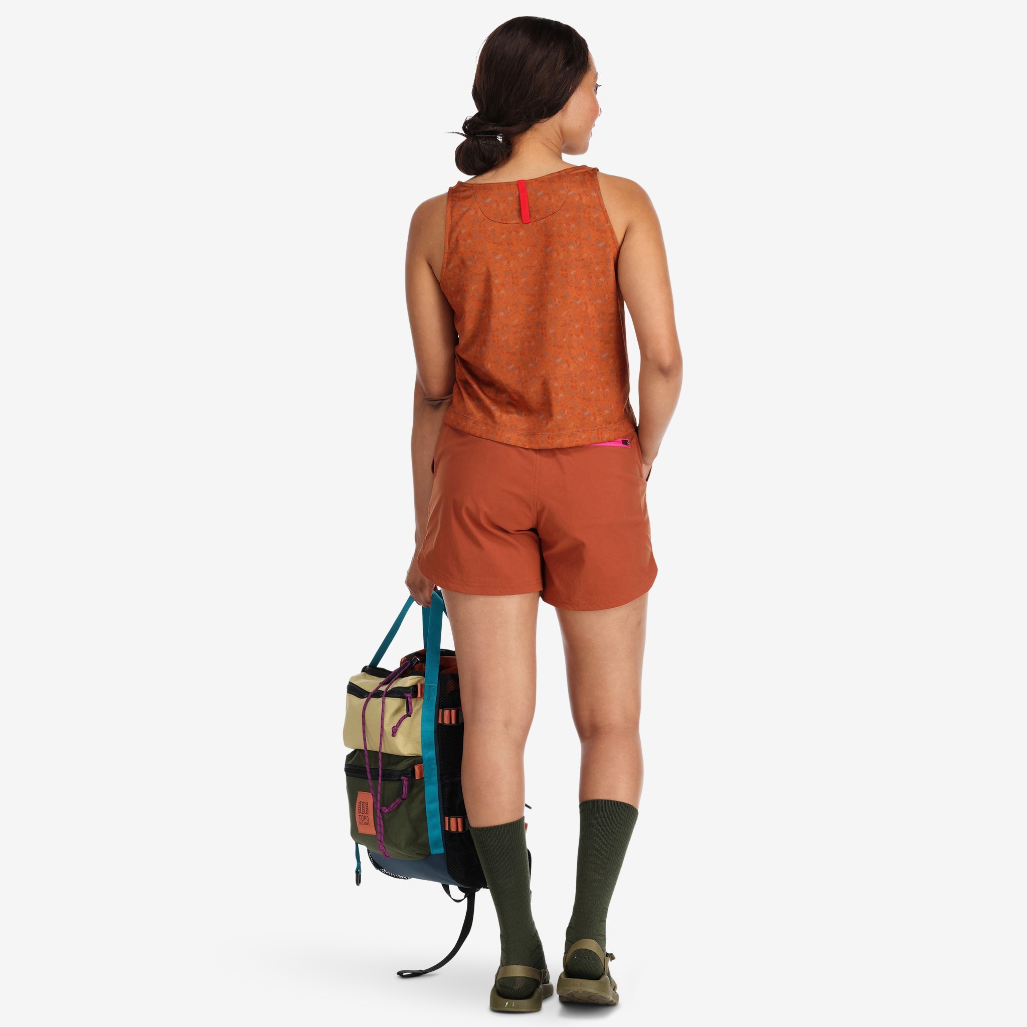 General shot of back of Topo Designs Women's 30+ UPF moisture wicking River Tank top in clay orange terrazzo print on model.