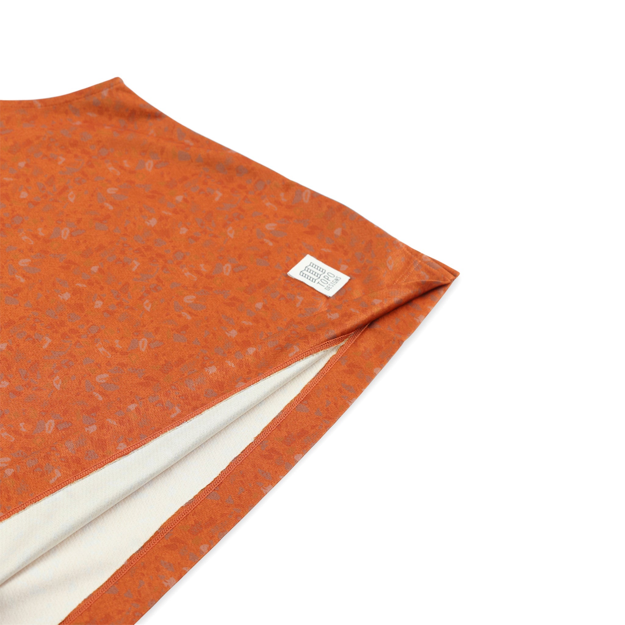 General shot of Topo Designs logo patch on Women's 30+ UPF moisture wicking River Tank top in clay orange terrazzo print.