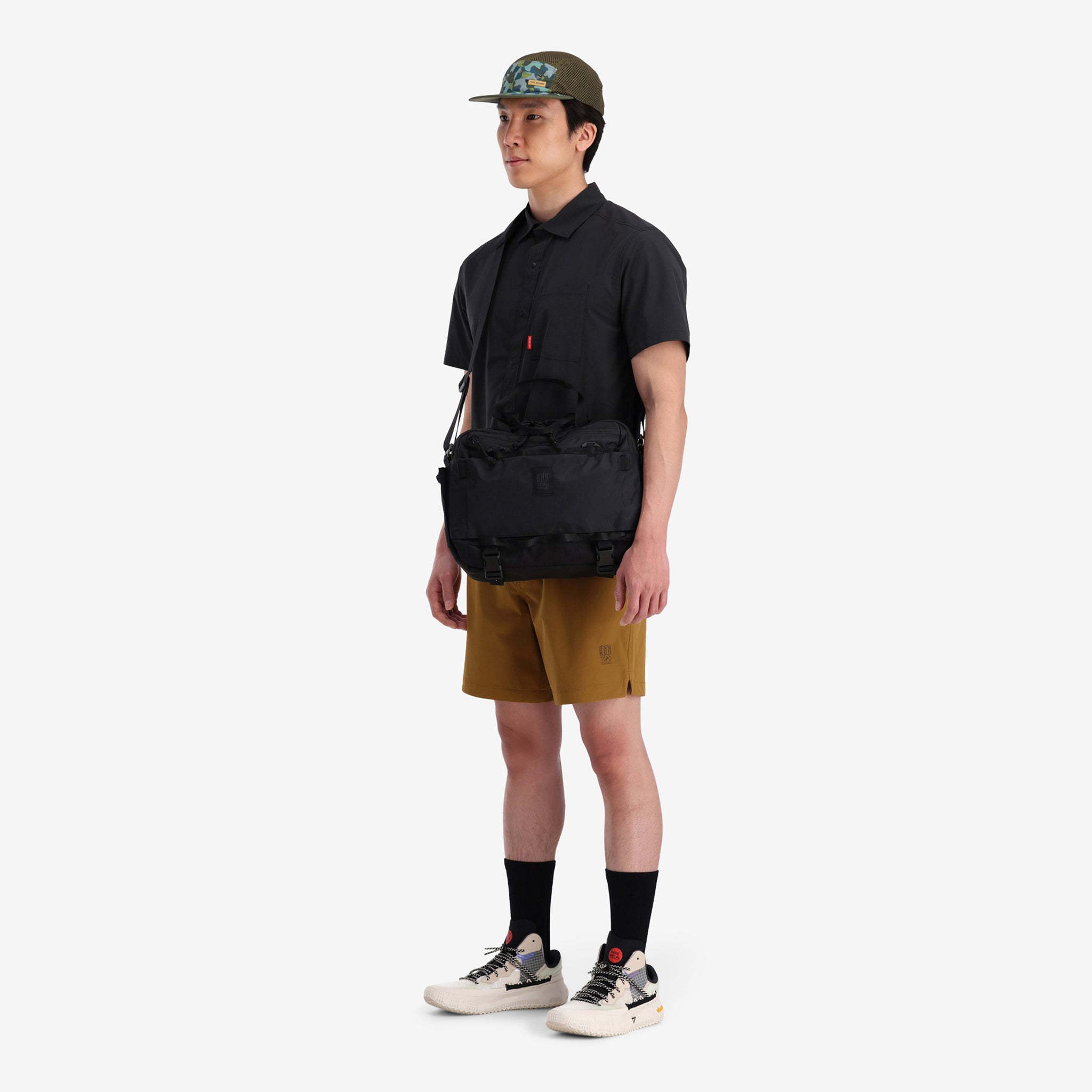 General shot of crossbody view of model with the Topo Designs Mountain Cross Bag in recycled "Black" nylon.