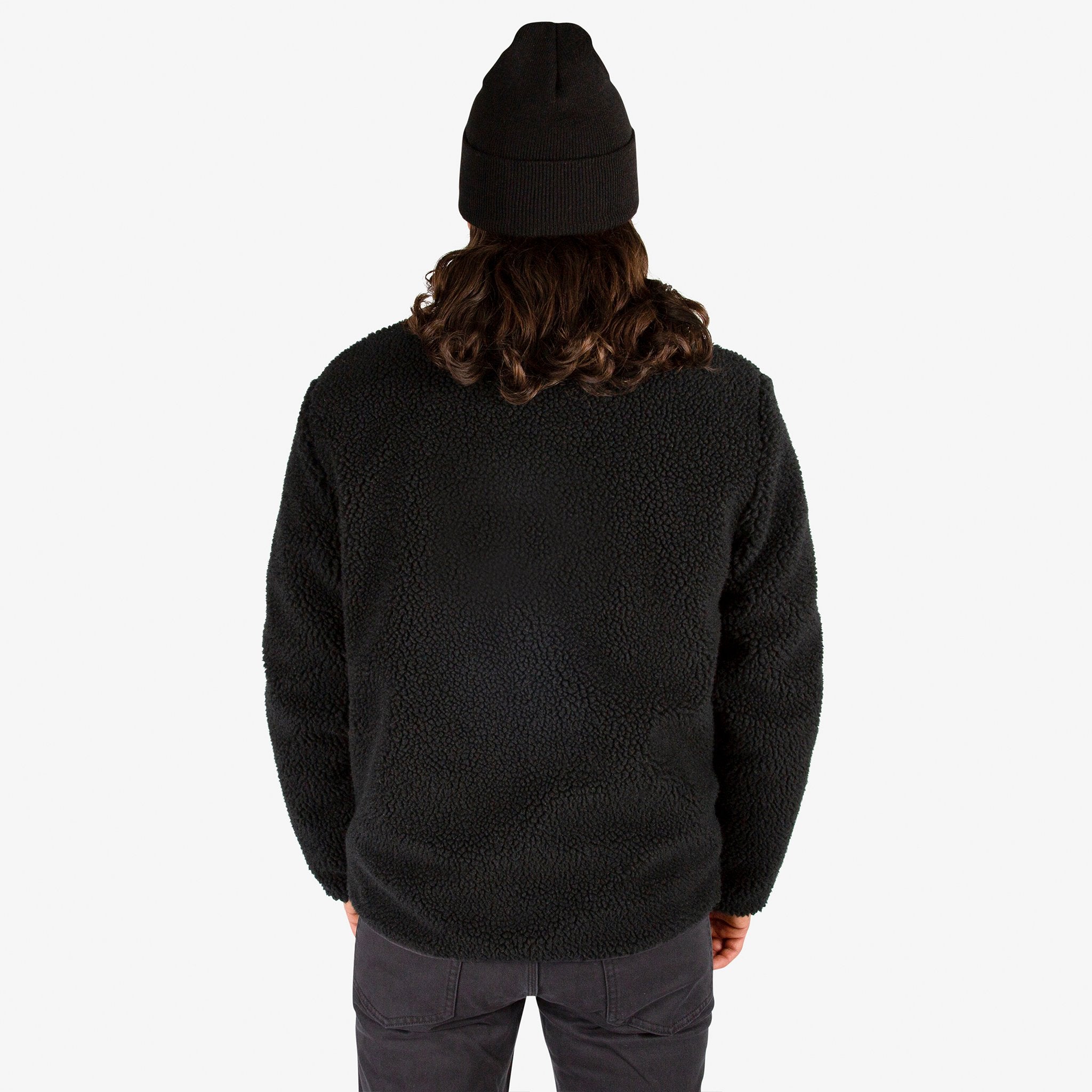 General close-up back model shot of Topo Designs Men's Sherpa Jacket in Black showing sherpa fleece side.